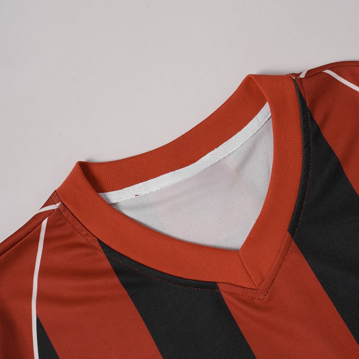 Close-up of a red football jersey with black flame stripes, white piping, and a V-neck collar