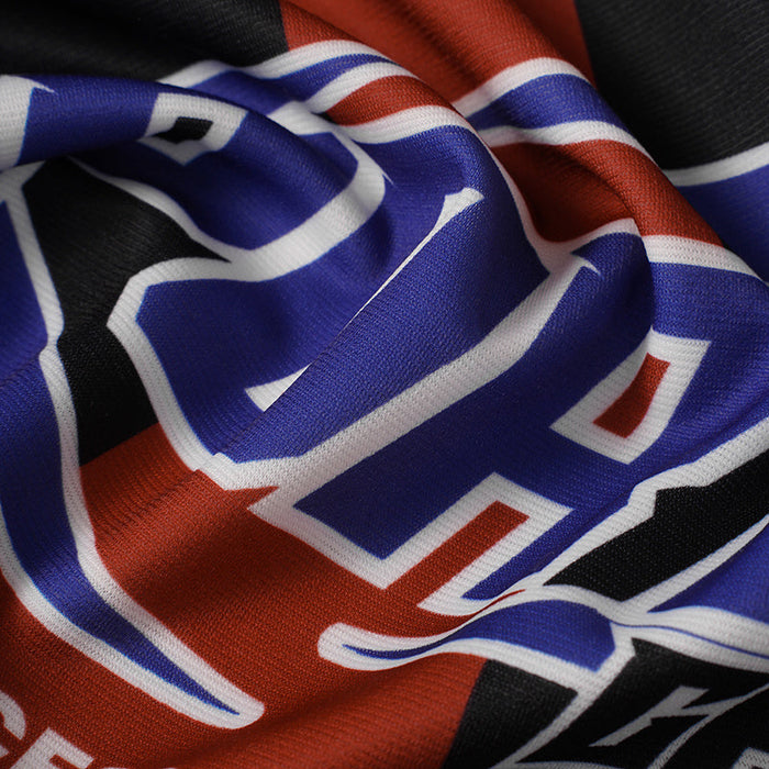 Close-up of a bold blue, red, black and white football jersey with large number print and flame stripe detailing
