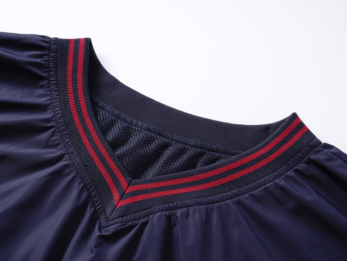 Close-up of navy V-neck collar with red stripes and mesh lining
