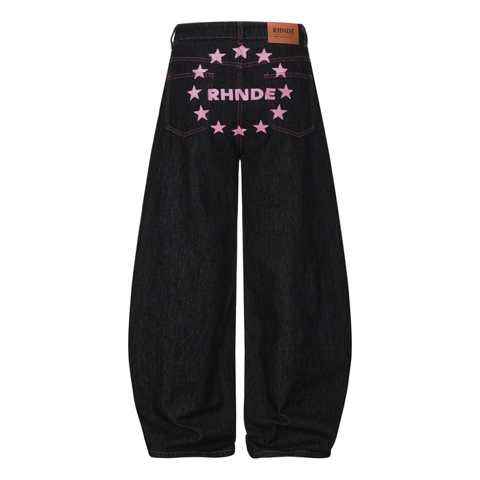 Back view of black wide-leg denim pants with pink star embroidery and RHNDE patch