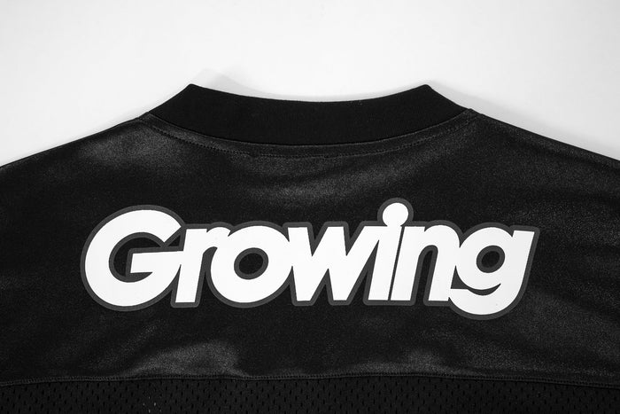 Close-up of black jersey back neckline with Growing logo print
