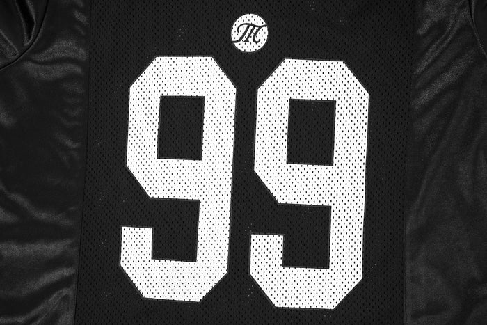 Close-up of black mesh jersey front showing chest logo and number detail