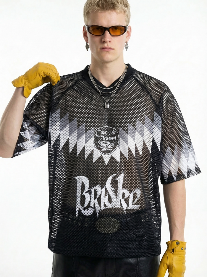 Black mesh jersey T-shirt with bold graphic print, worn by a model with yellow gloves and amber sunglasses