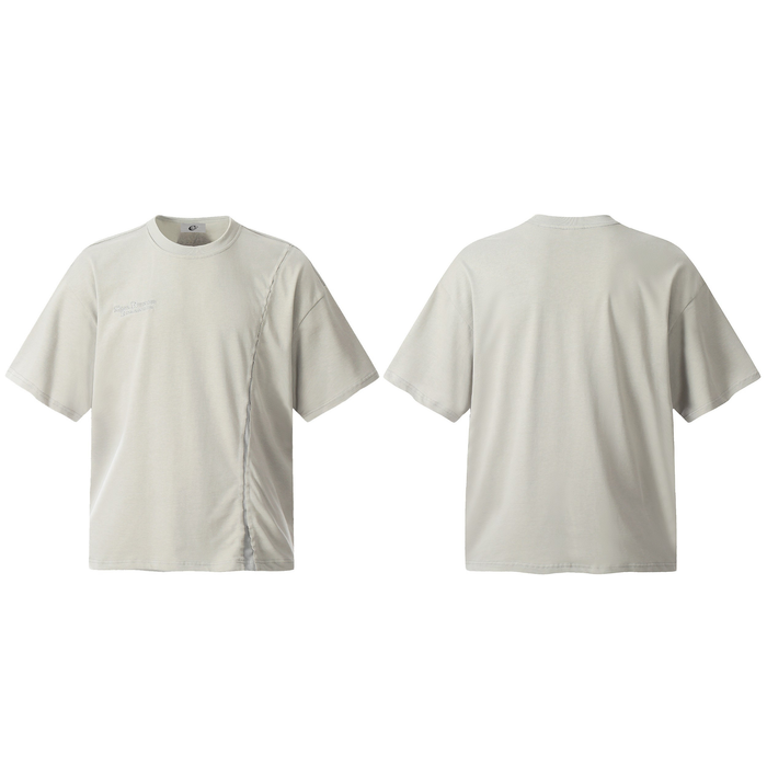 Front and back view of a light stone oversized cotton tee with an asymmetric curved front seam and tonal micro-logo