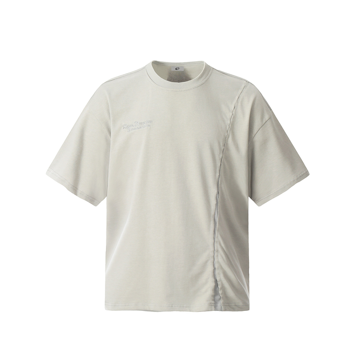 Beige asymmetric stitch tee with short sleeves, crew neck, and subtle chest embroidery on a clean white background