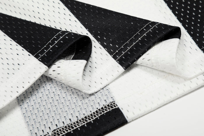 Close-up of sleeve fabric folds on black and white striped jersey with stitched seams