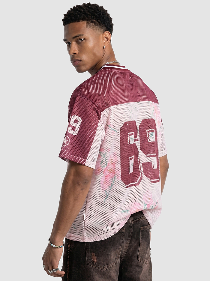 Model wearing a maroon and white floral mesh jersey T-shirt with bold 69 print on the back, styled streetwear look