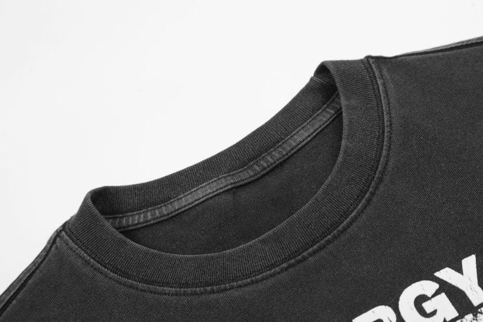 Close-up of a black vintage washed graphic T-shirt with ribbed crew neck and distressed white print