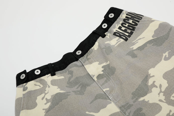 Close-up of upper side of gray camouflage shorts with black waistband and printed lettering