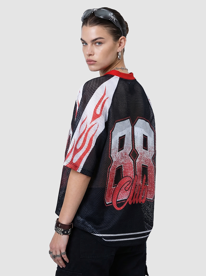 Model wearing black mesh jersey T-shirt with red flame graphics and bold 88 club print on back, streetwear style