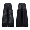 Front and back view of black wide-leg denim pants with cracked white texture contrast panels and layered waistband