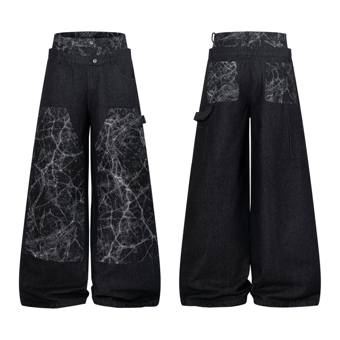 Front and back view of black wide-leg denim pants with cracked white texture contrast panels and layered waistband