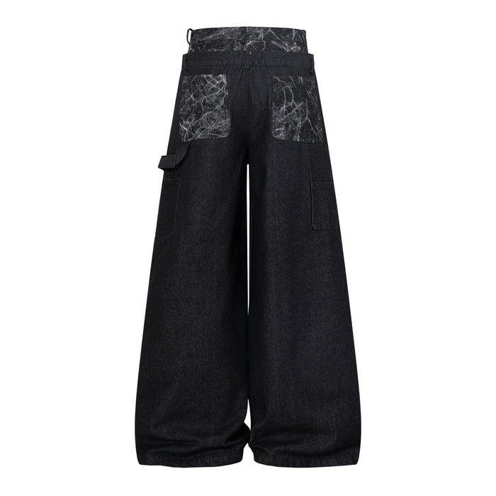 Back view of black wide-leg denim pants with cracked panel pockets and side strap detail