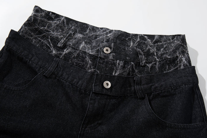Close-up of black denim waistband with cracked panel trim and two button closures