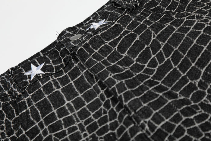 Close-up of black pants waistband with white star embroidery and button