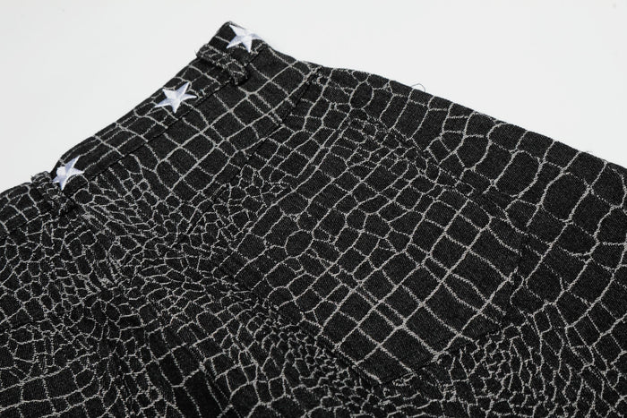 Close-up of black pants waistband and textured crocodile-style pattern