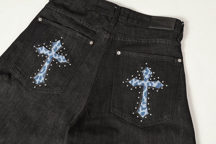 Back waist close-up showing cross pocket details and black denim patch label