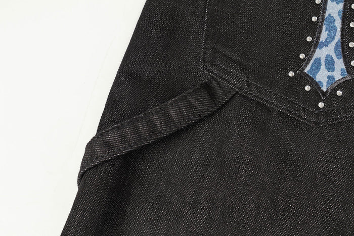 Close-up of one back pocket with blue cross appliqué and silver studs