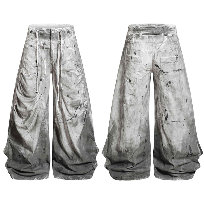 Front and back view of grey dirty wash balloon jeans with paint splatter detailing and extended white drawstrings
