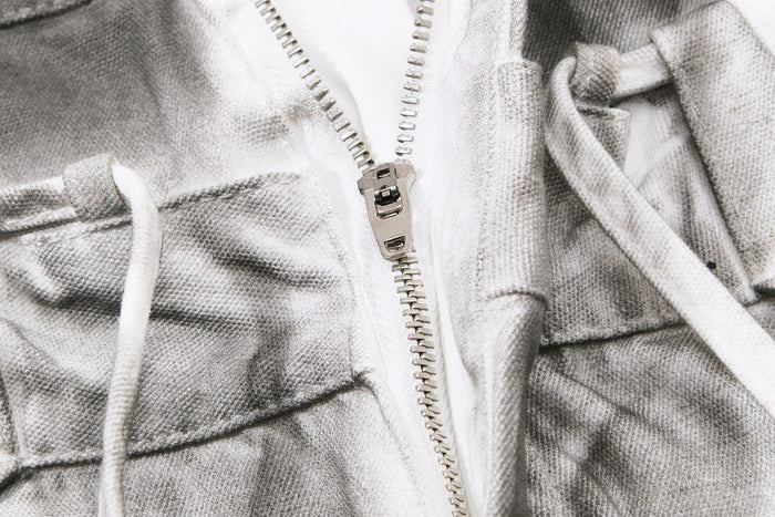 Close-up of metal zipper and white drawstring on gray balloon jeans