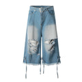 Front view of light blue wide-leg distressed denim jorts with built-in belt, ripped knees, and frayed hem tie straps