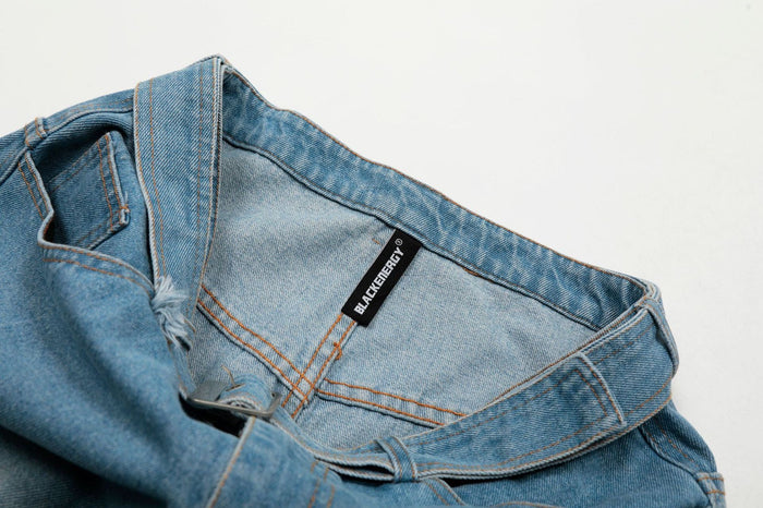 Interior waistband detail with black brand label on light wash denim jorts
