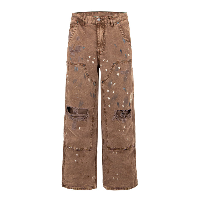 Front view of brown distressed denim pants with paint splatter and ripped knees