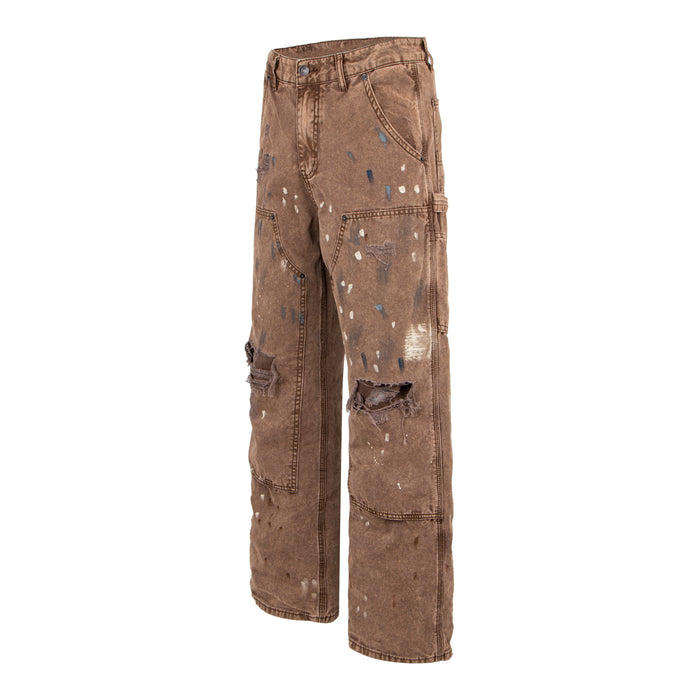 Three-quarter front view of brown distressed workwear denim pants with ripped knees