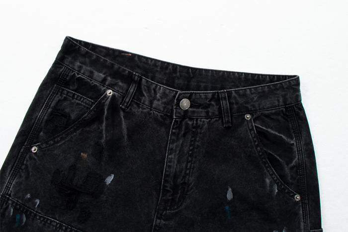 Close-up of black denim waistband with button, belt loops and distressed finish