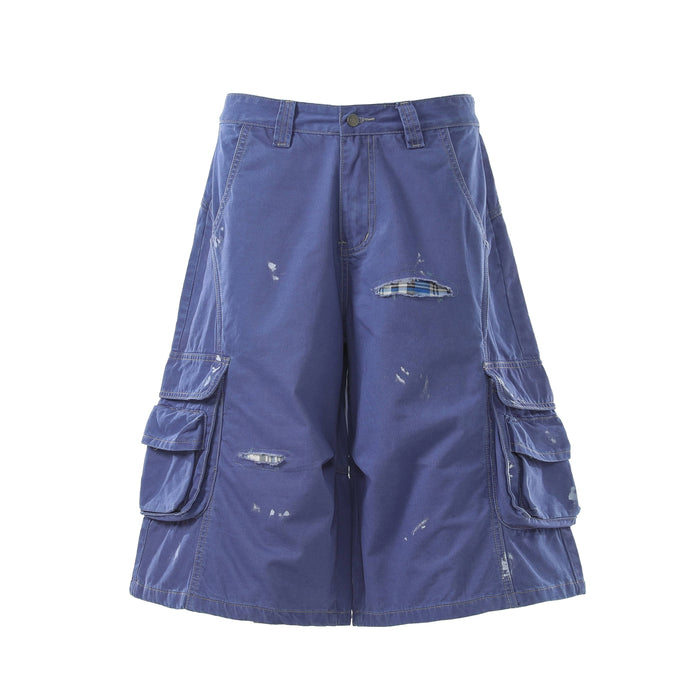 Blue distressed cargo shorts front view with button waist and plaid-reinforced rip
