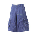 Blue cargo shorts front view with plaid patch at ripped opening and side flap pockets