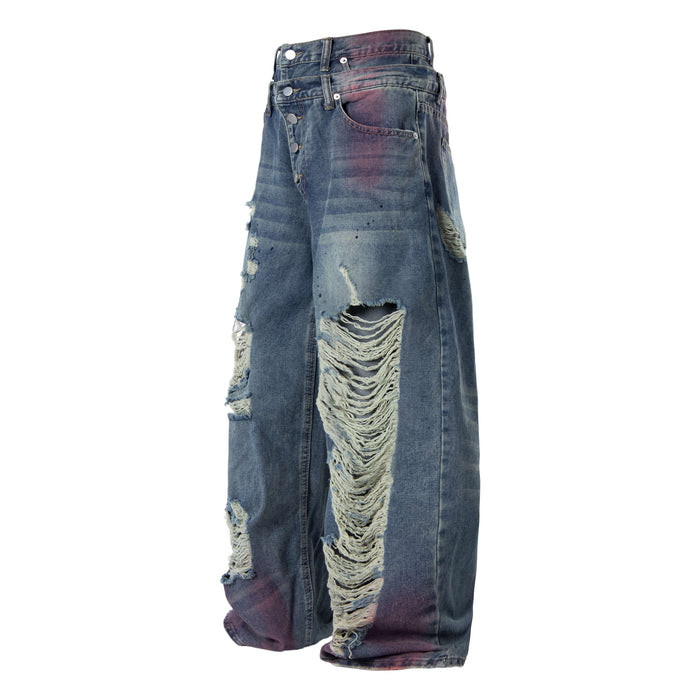 Front angled view of wide-leg jeans with button fly, heavy rips, and faded blue-purple wash