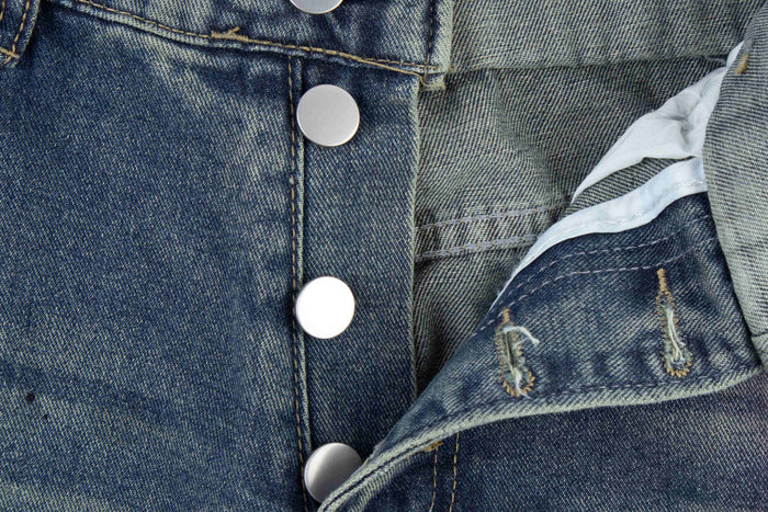 Close-up of the button fly and inner waistband on blue washed denim jeans