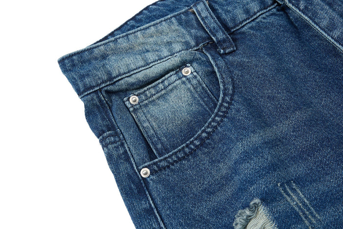 Front pocket close-up on blue jeans with metal rivets and faded denim