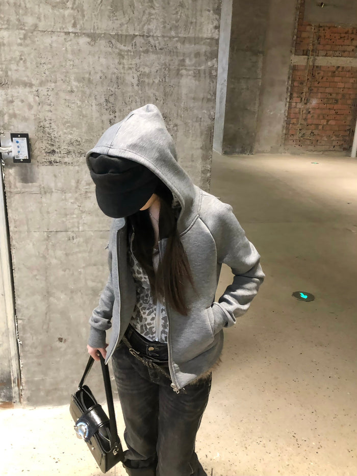 Model wearing grey zip-up hoodie with leopard-print inner layer