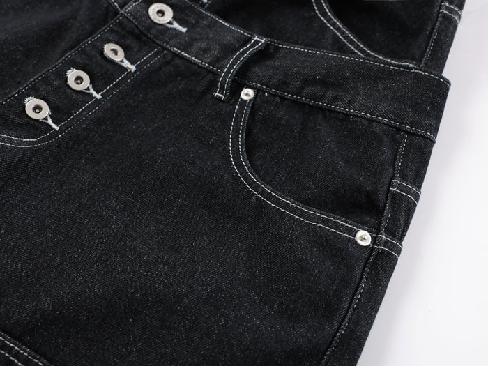Close-up of the front fly and utility pocket on black denim pants