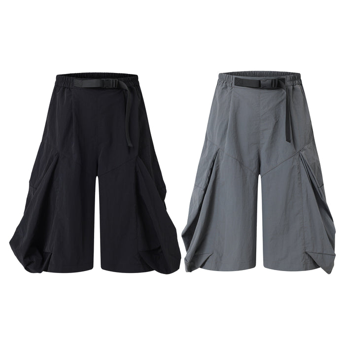 Omirad draped wide-leg shorts in black and grey, featuring exaggerated side panels and adjustable webbing belt waistband