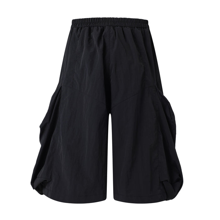 Black wide-leg shorts, back view with elastic waistband and draped side volume