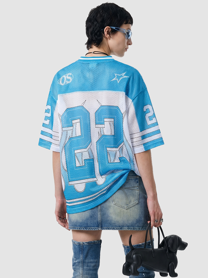Oversized blue mesh jersey T-shirt with large number 22, worn with denim skirt and boots