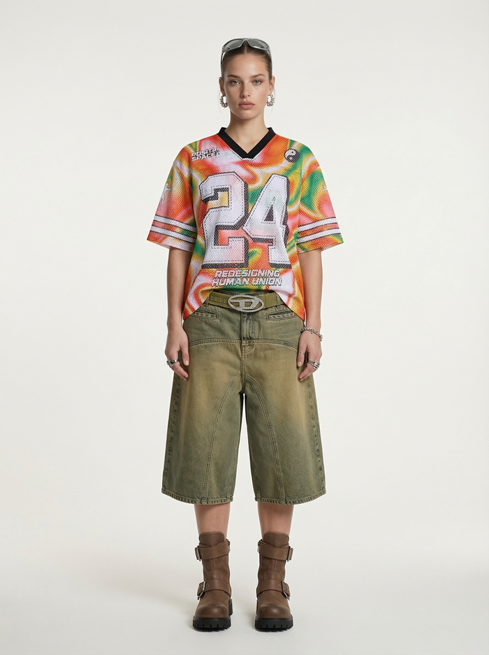Model wearing a colorful gradient mesh jersey T-shirt with large 24 graphic, olive wide-leg shorts, and brown boots