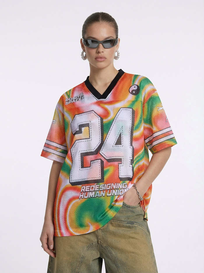 Model wearing a colorful liquid gradient mesh jersey T-shirt with bold number 24 print and black V-neck trim