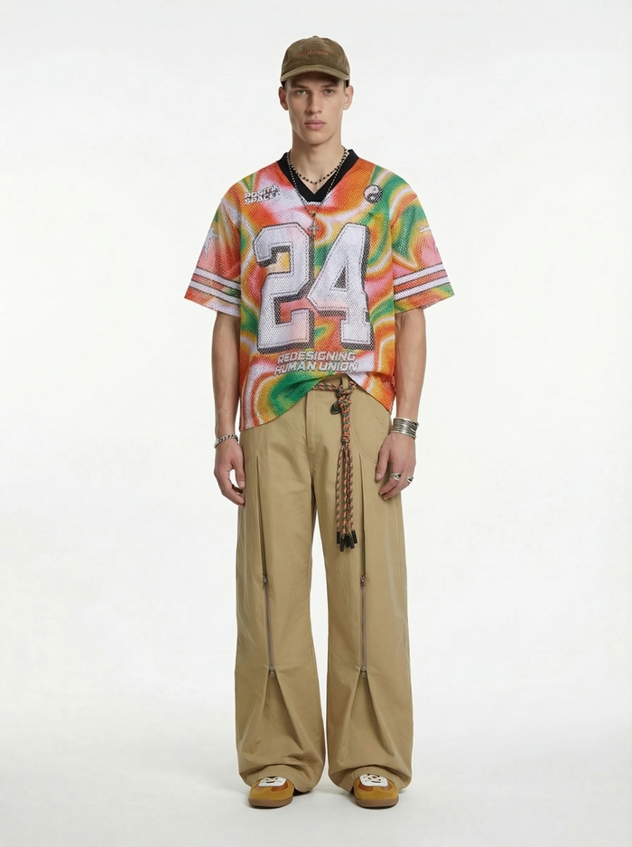 Model wearing a colorful liquid gradient mesh jersey T-shirt with large 24 graphic, beige cargo pants, and cap