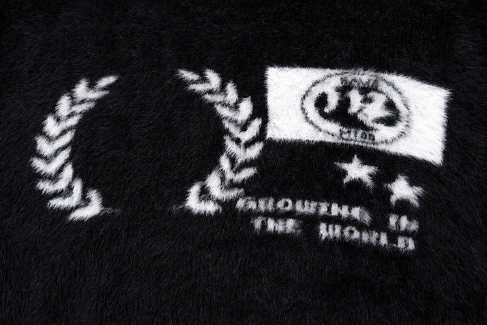 Close-up of the front graphic on the black fuzzy pullover sweater