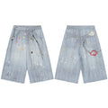 Front and back view of light-blue wide-leg denim shorts with colorful gem graphics, paint splatter, and silver chain charm de