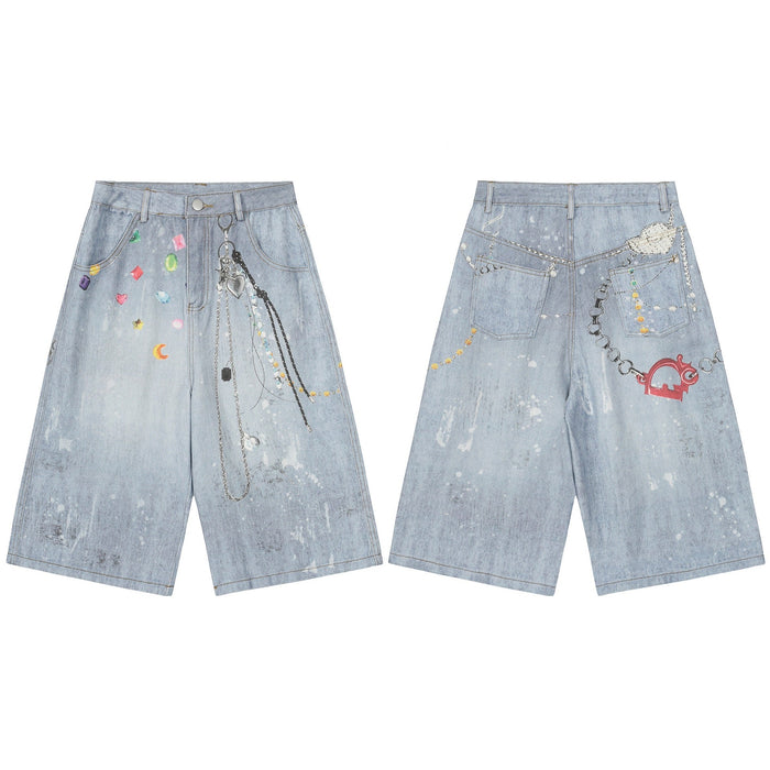 Front and back view of light-blue wide-leg denim shorts with colorful gem graphics, paint splatter, and silver chain charm de