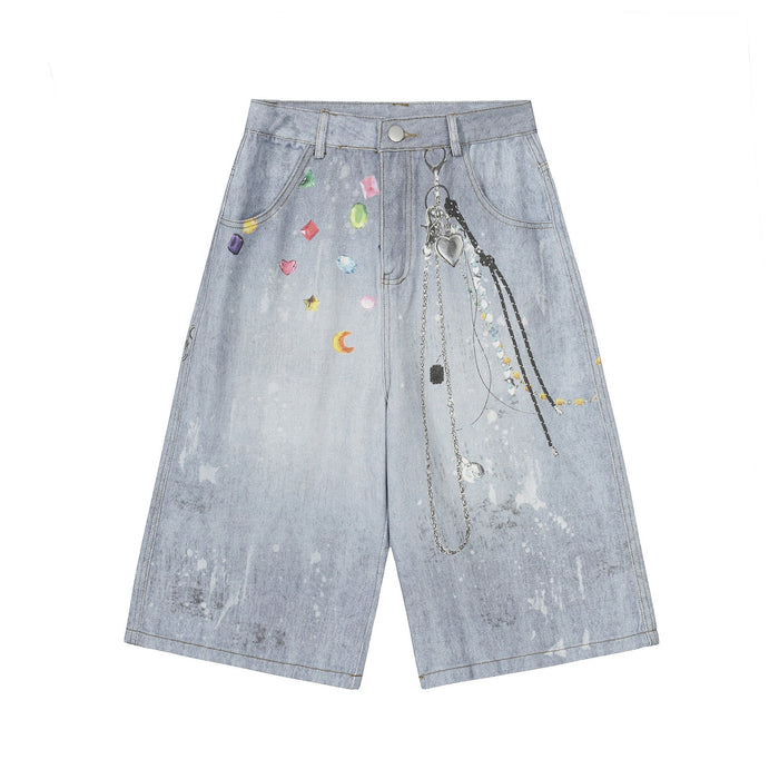 Front view of light wash wide-leg denim shorts with gem print and hanging chain graphic