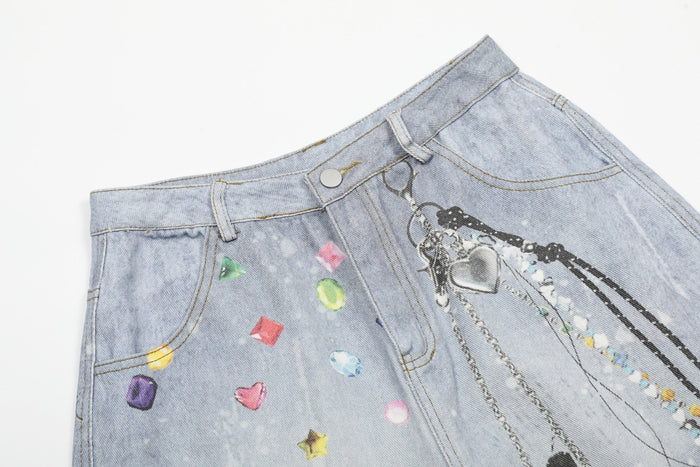 Close-up of front waistband and pocket on light wash denim shorts with chain and gem graphics