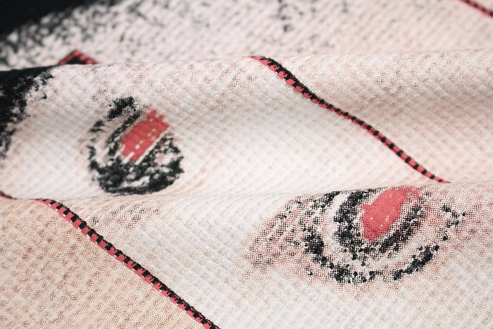 Close-up of black streetwear T-shirt fabric with glitch-style cat graphic in pink, black, and white accents