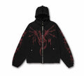 Black zip-up hoodie with red gothic dragon graphic print across chest and sleeves, studded hood detail