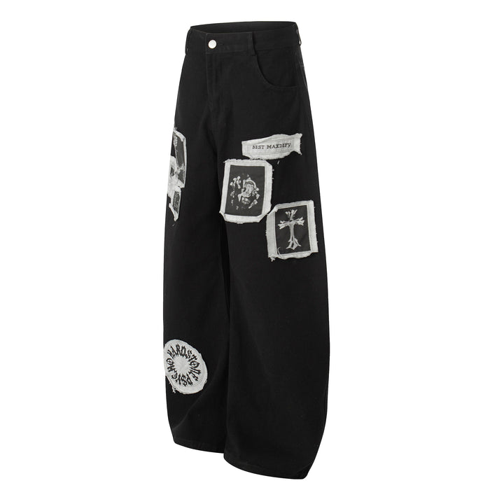 Black wide-leg pants with white patch graphics and frayed appliqué details, front view